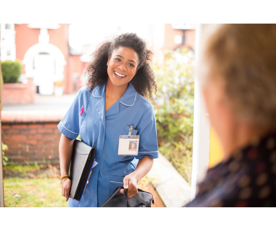 Smiling carer stepping in the front door of a patients house
